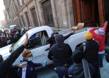 Normalistas de Ayotzinapa derriban una de las puertas del Palacio Nacional para presionar a López Obrador
