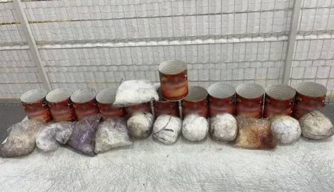 Descubren 12 kg de drogas ocultas en latas de salsa para pizza.